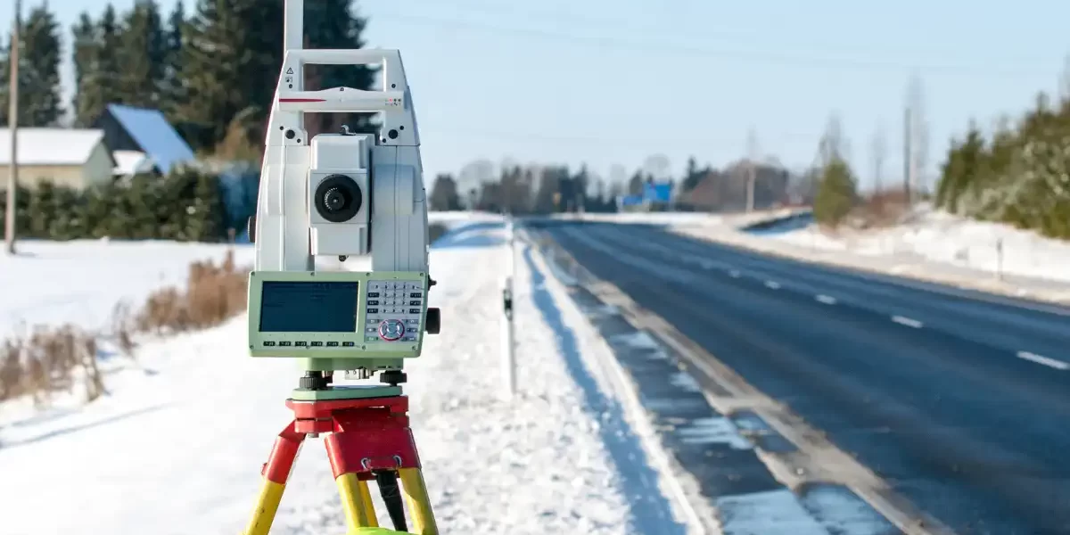 commercial-land-surveyor-ontario-1 Using a commercial land survey tripod during snow.